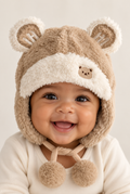 Baby wearing khaki plush bear-ear hat, front view